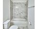 Bathroom with marble-look tile surround on the tub and shower at 304 Denna Ln, Auburndale, FL 33823