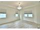 Bright bedroom featuring hardwood-style floors, and a large tray ceiling with modern chandelier at 304 Denna Ln, Auburndale, FL 33823