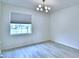 Light-filled bedroom features wood floors, modern lighting, and a large window with blinds at 304 Denna Ln, Auburndale, FL 33823