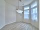 Bright dining room with wood floors, sheer curtains, and modern chandelier lighting at 304 Denna Ln, Auburndale, FL 33823