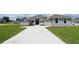 Charming single-Gathering home with stone accents, light gray paint, attached garage, and a large front yard at 304 Denna Ln, Auburndale, FL 33823