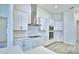 Modern kitchen features stainless steel appliances, white cabinetry, and stylish range hood at 304 Denna Ln, Auburndale, FL 33823