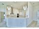 Open-concept kitchen boasts white cabinets, stainless steel appliances, and elegant pendant lighting at 304 Denna Ln, Auburndale, FL 33823