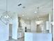 Spacious kitchen showcasing white cabinetry, stainless steel appliances, and stylish lighting fixtures at 304 Denna Ln, Auburndale, FL 33823