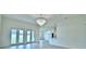 Bright living room with wood floors, a modern chandelier, and an open floor plan to the kitchen at 304 Denna Ln, Auburndale, FL 33823