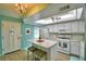 Charming kitchen with white cabinets, granite island, and light teal walls at 345 24Th Nw St # 30, Winter Haven, FL 33880