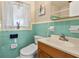 Clean bathroom with teal tile, updated toilet, and vanity at 412 Hillcrest Se Dr, Winter Haven, FL 33884