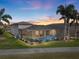 Backyard view of home with pool and lush landscaping at sunset at 4240 Dunmore Dr, Lake Wales, FL 33859