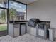 Outdoor kitchen with grill, sink, mini-fridge, and granite countertop at 4240 Dunmore Dr, Lake Wales, FL 33859