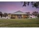 Screened porch overlooking a large grassy backyard at sunset at 524 Lake Suzanne Dr, Lake Wales, FL 33859