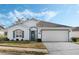 White house with teal accents, two-car garage, and landscaped lawn at 524 Lake Suzanne Dr, Lake Wales, FL 33859