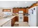 Spacious kitchen with wood cabinets, white appliances, and tile flooring at 524 Lake Suzanne Dr, Lake Wales, FL 33859