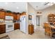 L-shaped kitchen with wood cabinets, white appliances, and a dining area at 524 Lake Suzanne Dr, Lake Wales, FL 33859