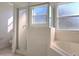 Bathroom featuring a glass door shower, soaking tub, and frosted windows that offer privacy at 746 Platypus Ct, Kissimmee, FL 34759