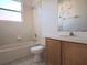 Well-lit bathroom featuring a sink, toilet, and bathtub with white tiled walls at 746 Platypus Ct, Kissimmee, FL 34759