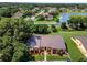 An aerial view of a neighborhood with lush green trees and a tranquil lake, showcasing community living at 768 Canberra Rd, Winter Haven, FL 33884