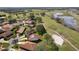 An aerial view of houses with red tile roofs next to a golf course and lake at 768 Canberra Rd, Winter Haven, FL 33884