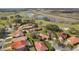 Aerial view of houses with red tile roofs surrounding a lake and golf course at 768 Canberra Rd, Winter Haven, FL 33884