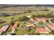Aerial view of homes with red tile roofs, a golf course, and a highway nearby at 768 Canberra Rd, Winter Haven, FL 33884