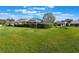 Spacious backyard with lush green grass and manicured hedges, ideal for outdoor activities at 768 Canberra Rd, Winter Haven, FL 33884