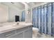 Bathroom featuring blue striped shower curtain, a vanity, and a large mirror at 768 Canberra Rd, Winter Haven, FL 33884