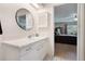 Bathroom with a white tiled counter and round mirror, leading to a view of the bedroom and its furnishings at 768 Canberra Rd, Winter Haven, FL 33884
