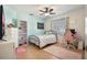 Bright bedroom with modern décor, featuring wood floors and a pink desk and chair at 768 Canberra Rd, Winter Haven, FL 33884