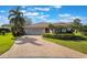 Charming single-story home featuring lush landscaping, a brick driveway, and a two-car garage at 768 Canberra Rd, Winter Haven, FL 33884