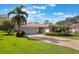 Charming home exterior with lush green lawn, tropical plants, and a brick driveway, creating a welcoming curb appeal at 768 Canberra Rd, Winter Haven, FL 33884