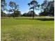 Green golf course with mature trees and lush green grass with a sand trap in the distance at 768 Canberra Rd, Winter Haven, FL 33884