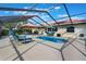 Outdoor living space with a screened-in pool area with lounge chairs and an umbrella-covered dining set at 768 Canberra Rd, Winter Haven, FL 33884