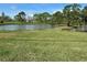 Scenic view of a tranquil pond surrounded by green grass and trees, offering a peaceful and picturesque setting at 768 Canberra Rd, Winter Haven, FL 33884