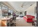 Spacious sun room with ample natural light, a desk setup, treadmill and a comfy red sofa at 768 Canberra Rd, Winter Haven, FL 33884