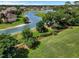 Aerial view of a home next to a lake with mature trees, with green grass surrounding at 768 Canberra Rd, Winter Haven, FL 33884