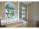 Spa-like bathroom with soaking tub, walk-in shower, and large window at 8323 W Lake Marion Rd, Haines City, FL 33844