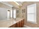 Bathroom with wood cabinets, marble countertop, and large mirror at 8323 W Lake Marion Rd, Haines City, FL 33844
