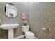 Powder room with pedestal sink and floral wallpaper at 8323 W Lake Marion Rd, Haines City, FL 33844