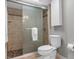 Modern bathroom features a glass shower door, pebble floor, and tiled walls, creating a sleek and inviting space at 1 Casarena Ct, Winter Haven, FL 33881
