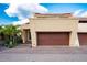 Modern home featuring a large garage, tan stucco, and paver driveway under a blue sky at 1 Casarena Ct, Winter Haven, FL 33881