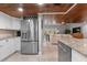 Modern kitchen featuring stainless steel appliances, granite countertops, and a rich wood ceiling open to a bright living space at 1 Casarena Ct, Winter Haven, FL 33881