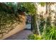 Charming side yard features a brick pathway, lush landscaping, and access to a serene outdoor seating area at 1 Casarena Ct, Winter Haven, FL 33881