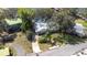 Aerial view of a home with a well-manicured lawn, driveway, mature trees, and a glimpse of the serene lake nearby at 1048 Sunset Trail, Babson Park, FL 33827