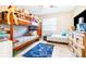 Bright bedroom features a wooden bunk bed, ceiling fan, and gaming-themed decor at 1048 Sunset Trail, Babson Park, FL 33827