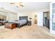 Cozy bedroom features a ceiling fan, mirrored closet doors, and a view of the ensuite bathroom at 1048 Sunset Trail, Babson Park, FL 33827