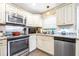 The stylish kitchen features white cabinets, stainless appliances and granite countertops at 1048 Sunset Trail, Babson Park, FL 33827