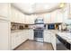 Stylish kitchen features white cabinets, stainless appliances, and granite countertops at 1048 Sunset Trail, Babson Park, FL 33827