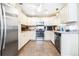 The stylish kitchen features white cabinets, stainless appliances and granite countertops at 1048 Sunset Trail, Babson Park, FL 33827