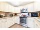 The well-lit kitchen features white cabinets, stainless appliances, and granite countertops at 1048 Sunset Trail, Babson Park, FL 33827