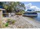 Enjoy the lake view, featuring a boat on the sand, lounge seating, and a cozy gathering spot, creating a perfect waterfront getaway at 1048 Sunset Trail, Babson Park, FL 33827