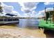 A pontoon boat is seen docked by a slide and clear water, perfect for waterfront activities and enjoying the lake view at 1048 Sunset Trail, Babson Park, FL 33827